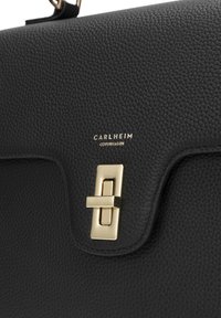 Black textured leather bag featuring a gold hardware clasp and brand logo "CARLHEIM COPENHAGEN." Rectangle shape with a flap closure.
