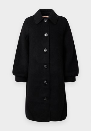 Černý vlněný kabát s límcovým výstřihem, dlouhými rukávy a šesti velkými knoflíky vpředu. Má rovný střih a měkkou strukturu.