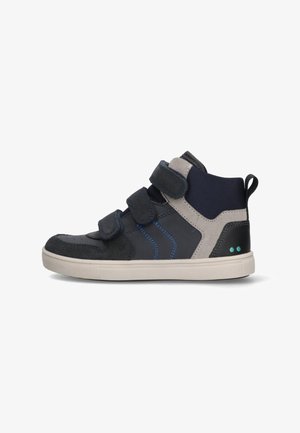Black and gray high-top sneakers with hook-and-loop fasteners, blue stitching, and a textured fabric accent. Rubber sole with a patterned design.