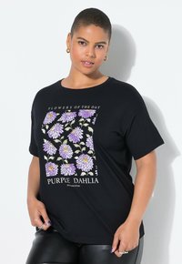 Černé bavlněné tričko s květinovým vzorem obsahující fialové dalie a text "KVĚTINY DNE." Kulatý výstřih a krátké rukávy.