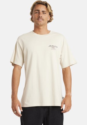Kremowa koszulka z krótkim rękawem wykonana z bawełny, z małym graficznym logo po lewej stronie klatki piersiowej. Luźny krój z okrągłym dekoltem.