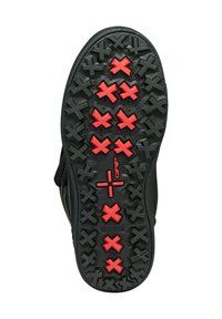 Suela de zapato negra con una superficie de agarre texturizada y acentos de goma roja. El patrón incluye cruces salientes para mayor tracción.