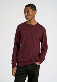 Bordeaux trui in een klassiek crew neck ontwerp, gemaakt van een zachte breimateriaal, met ribgebreide manchetten en zoom. De silhoët is getailleerd.