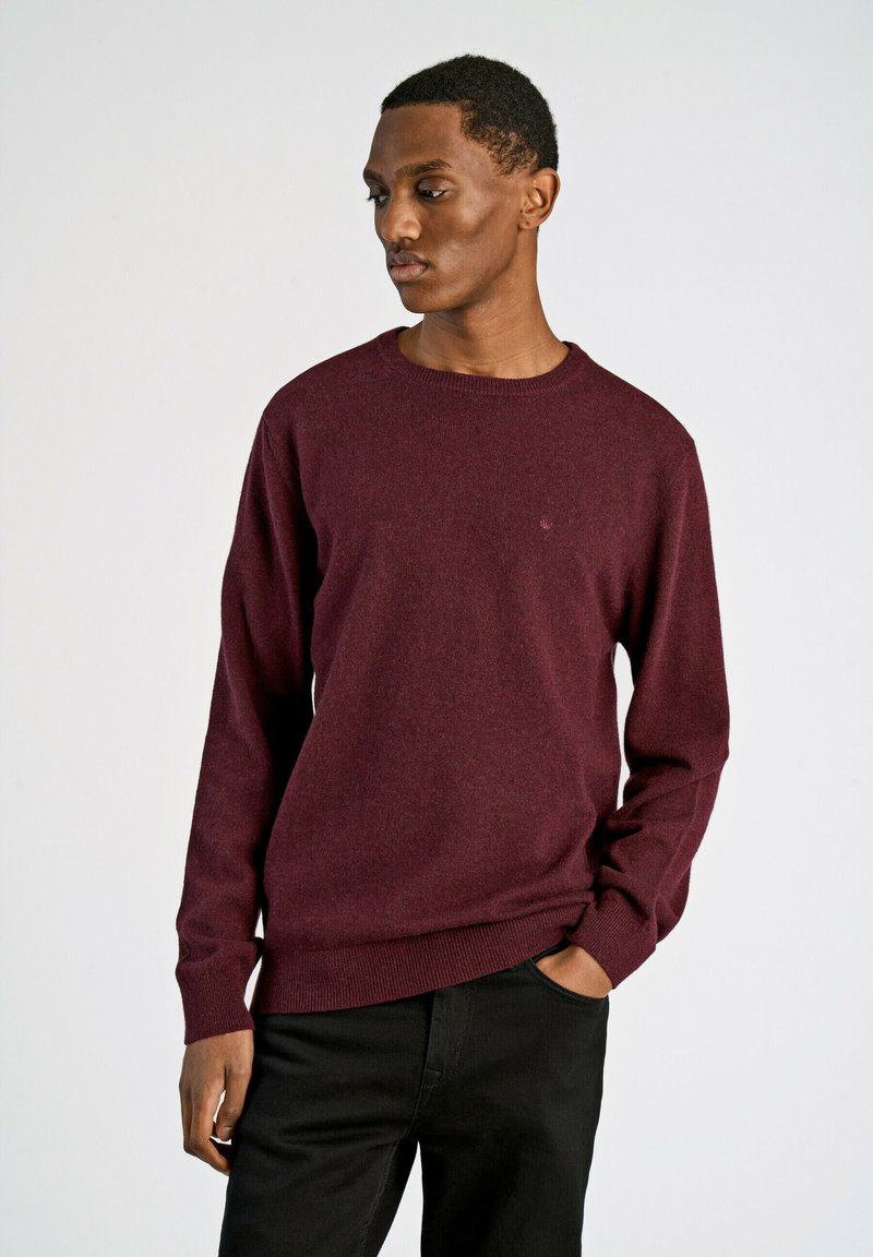 Bordeaux trui in een klassiek crew neck ontwerp, gemaakt van een zachte breimateriaal, met ribgebreide manchetten en zoom. De silhoët is getailleerd.