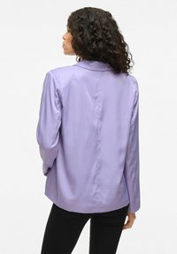 Lilac blazer gemaakt van gladde stof, met een gestructureerde kraag, lange mouwen en een getailleerde silhouette, weergegeven vanuit een achteraanzicht.