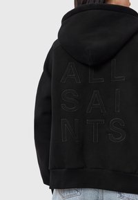Felpa nera con cappuccio caratterizzata da lettering in rilievo "ALL SAINTS" sulla schiena, con una texture morbida e orlo a costine. Design casual, vestibilità rilassata.