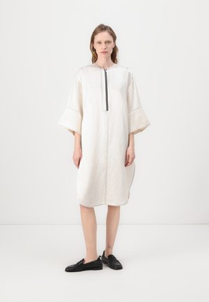 White knee-length dress with three-quarter bell sleeves, featuring a black zip closure and contrasting stitching along the seams.