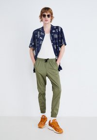 Jack & Jones JJIGORDON JJLANE VEGA - Trousers - deep lichen green