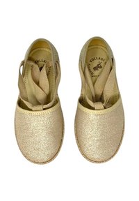 Scarpe in tessuto dorato con tomaia texture, punte tonde e suola piatta e morbida. Presentano ampie fascette elastiche per una vestibilità sicura.