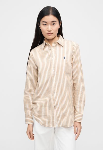 Pruhovaná košeľa na gombíky v béžovej a bielej farbe s golierom, s dlhými rukávmi a malým modrým logom na hrudi.