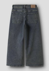 Blå vidbukse jeans i denim med to baklommer og en brun lærmerke på midjen, vist bakfra.
