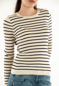 Maglione a righe crema e blu navy con scollatura rotonda, bottoni sulle spalle e design aderente. Materiale in misto cotone, superficie texturizzata.