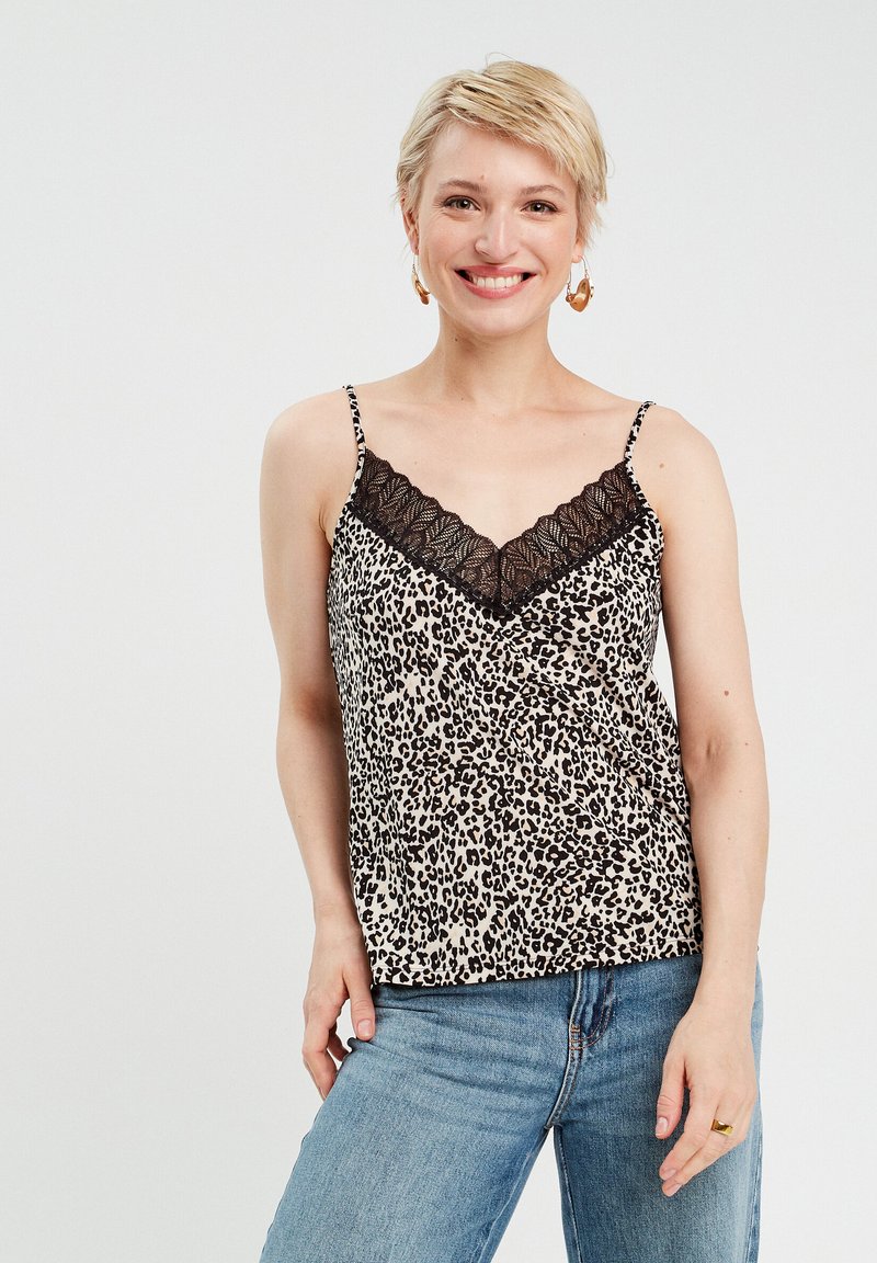 Leopardenmuster-Camisole mit V-Ausschnitt und schwarzem Spitzenbesatz; verstellbare Spaghetti-Träger; leichtes Material; getragen mit blauen Jeans.
