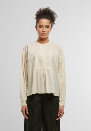Beige langermet bluse med knappest перед, plissert liv og rund hals. Har diskrete teksturer og skreddersydde ermer.