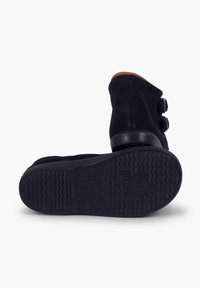Botine bleu marin din piele nubuc, cu două catarame laterale, vârf rotund și talpă din cauciuc texturat cu un model ondulat.