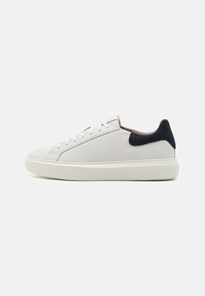 Sneakers bianchi in pelle con finitura testurizzata, tallone in suede blu navy a contrasto, punta rotonda e design classico con lacci.