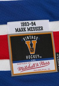 Mitchell & Ness Vintage Hockey-Label auf blauem, weißem und rotem Stoff, mit den Details "1993-94 Mark Messier" und NHL-Logo.
