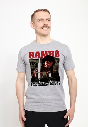 Graues Baumwoll-T-Shirt mit einem grafischen Aufdruck eines Charakters mit dunklem Haar und militärischen Elementen, der Text lautet "RAMBO" und darunter steht ein Zitat.