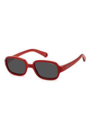 Occhiali da sole in plastica rossa con montatura rettangolare, lenti scure e stanghette sottili. Presentano un logo blu sul lato della montatura.