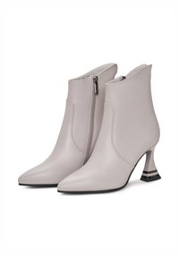 Szürke bőr bokacsizma, hegyes orral, oldalcipzárral és egyedi fém sarok kialakítással, amelyen vízszintes csík található.