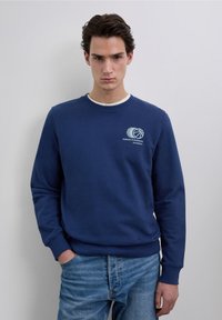 Sudadera azul marino de mezcla de algodón, cuello redondo, puños y dobladillo acanalados, con logo y texto de baloncesto en blanco en el pecho.