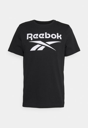 Czarna koszulka z krótkim rękawem z białym napisem i logo "Reebok" umieszczonym na środku klatki piersiowej, prezentowana na białym tle.