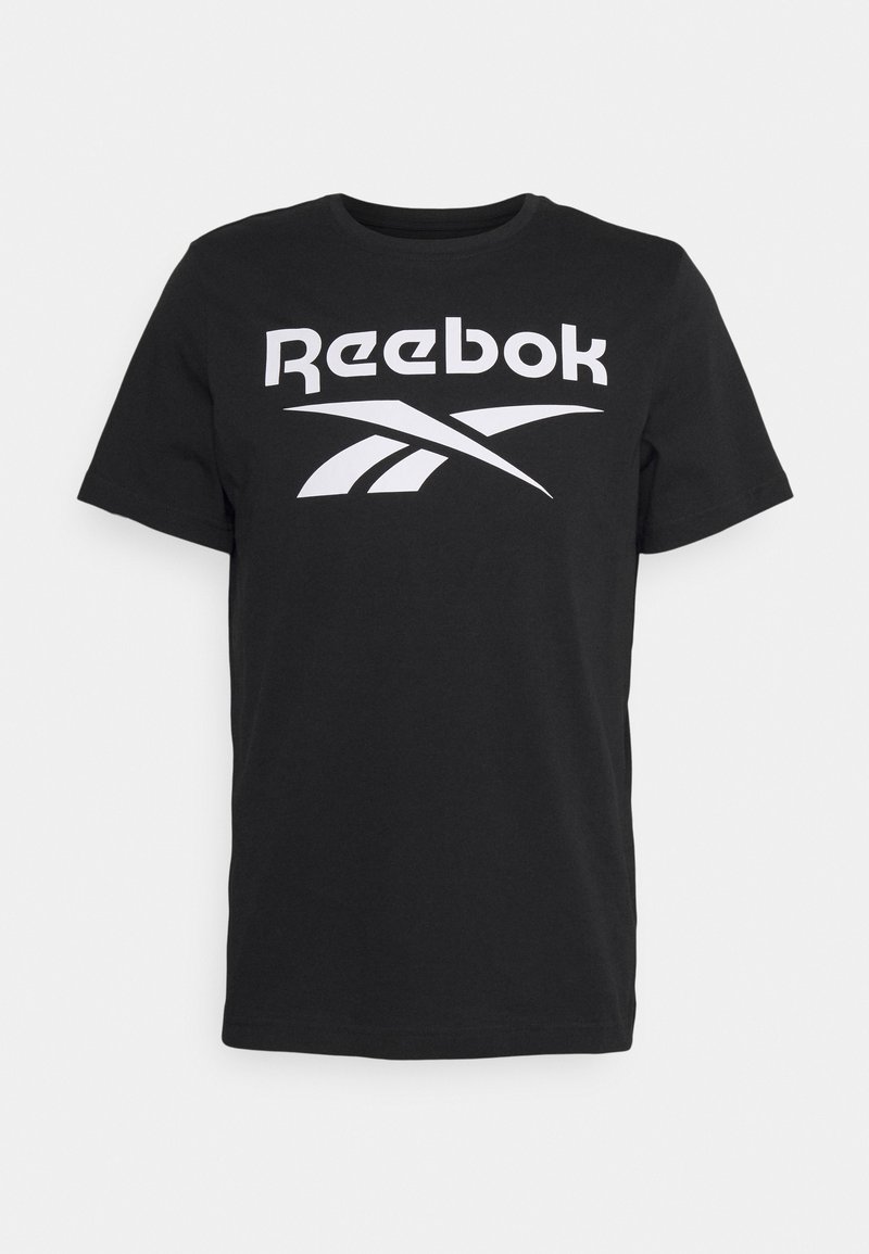 Černé tričko s krátkým rukávem s bílým textem a logem "Reebok" umístěným uprostřed hrudi, exponováno na jednoduchém bílém pozadí.