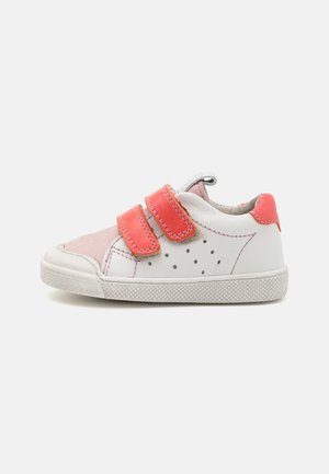 Weißer Sneaker mit rosa und korallefarbenen Akzenten, ausgestattet mit zwei Klettverschlüssen, perforiertem Design und strukturiertem Gummisohle.