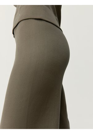 Żakietowa sukienka w kolorze oliwkowym z prążkowanym wzorem, o dopasowanym kroju, wykonana z elastycznego materiału. Posiada drapowany dekolt i bezszwowy design.