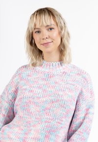 Strickpullover aus einer Mischung von pastellfarbenem Pink, Blau und Weiß. Er hat einen hohen Kragen und lockere Ärmel. Strukturmuster im Strick.