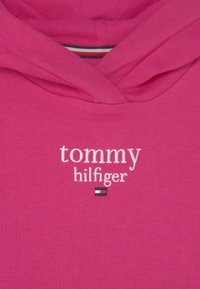 Roze katoenen hoodie met een witte geborduurde logo, "tommy hilfiger," en een klein vlagontwerp. Zachte textuur en verstelbare capuchon.