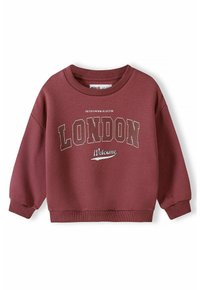 Felpa marrone con scollo rotondo, maniche lunghe e polsini a coste. Presenta un testo bianco che recita "LONDON" e "Welcome" in un carattere giocoso.