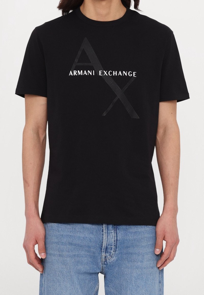 Svart bomullströja med en vit "Armani Exchange"-logotyp och en stiliserad "A" och "X" grafik. Korta ärmar och rund halsringning.