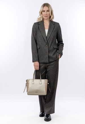 Costume gris ajusté avec un seul bouton, associé à un sac à main texturé doré et des chaussures noires. Design simple, lignes épurées et tons neutres.