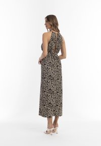 Beige és fekete leopárdmintás maxi ruha, magas nyakkivágással, hátsó kivágással és rugós derékrésszel a testhez simuló sziluettért.