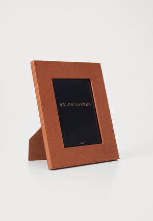 Cadre photo en cuir brun avec une finition texturée, comprenant un insert noir et une inscription dorée. Accueille une photo de 5x7 pouces. Conception sur pied.