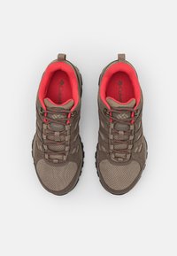 Brązowe buty trekkingowe z siateczkową cholewką i gumową podeszwą, z czerwonymi akcentami, pętlami oraz teksturowaną powierzchnią dla lepszej przyczepności.
