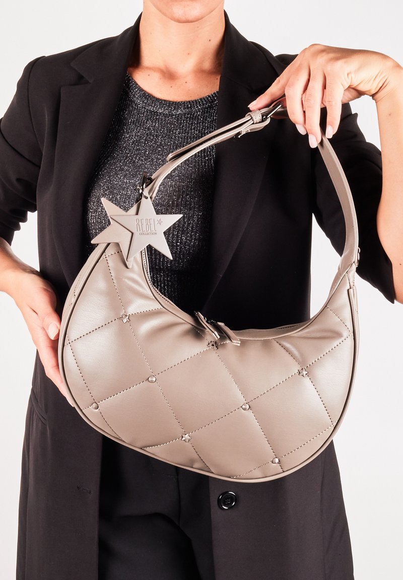 Grå faux læder hobo taske med quiltet design, der har cirkulære detaljer og et stjerneformet mærke mærket "REBEL COLLECTION."