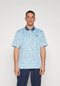Blå blomstermønstrete polo skjorte med marineblå krage, korte ermer og en avslappet passform. Materialet ser lett og pustende ut.