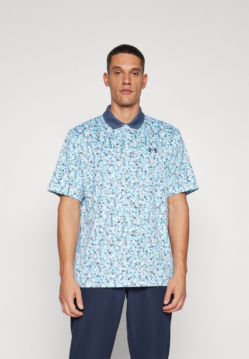 Polo à motif floral bleu avec un col marine, des manches courtes et une coupe décontractée. Le matériau semble léger et respirant.