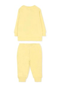 Felpa gialla in cotone e set di joggers coordinati. La felpa presenta maniche lunghe con polsini a coste; i pantaloni hanno una vita elastica e gambe affusolate.