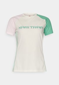 Īsām piedurknēm sporta krekls ar ribotu tekstūru. Krāsas ietver gaiši rozā, zaļu un baltu. Atšķiras ar drosmīgu "KARI TRAA" uzrakstu tirkīza krāsā.