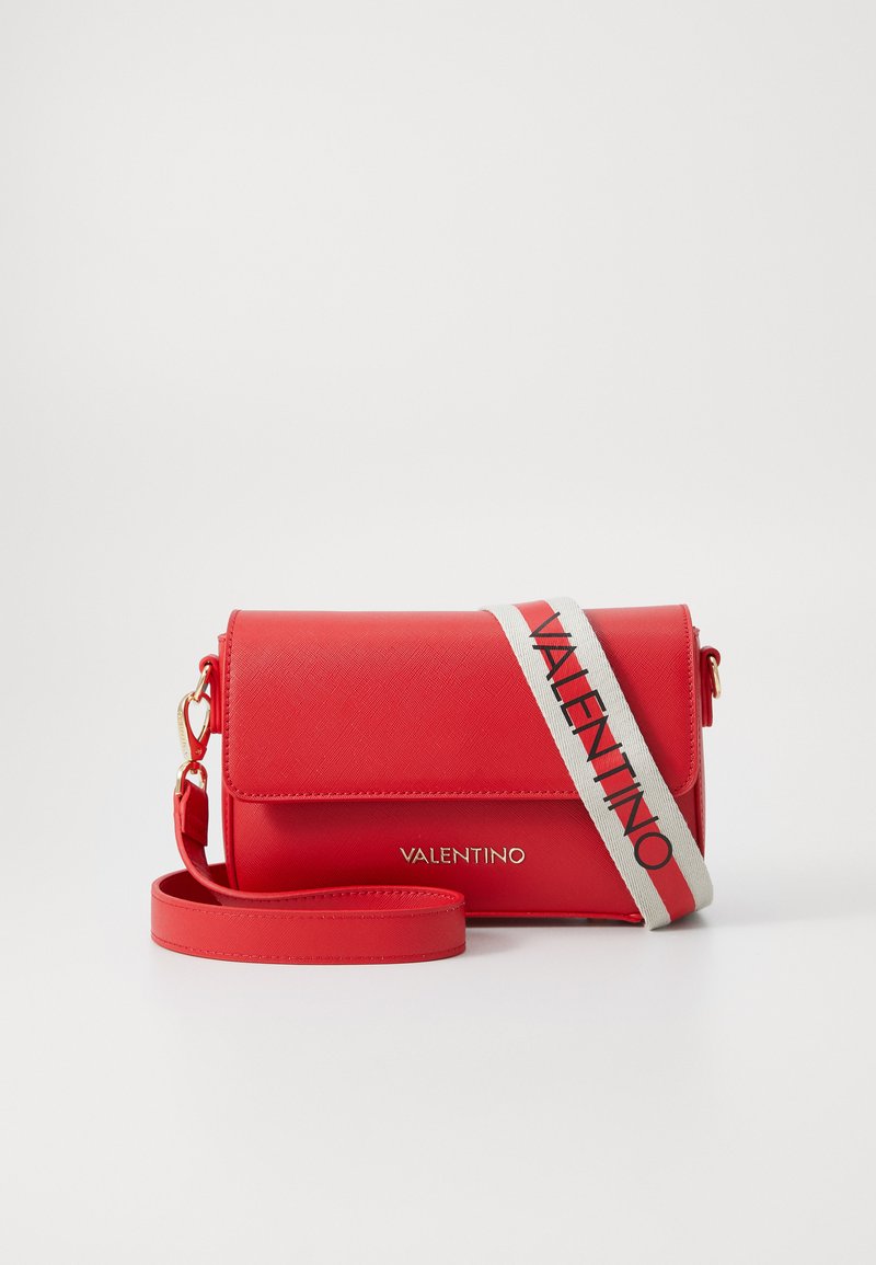 Borsa sintetica rossa con chiusura a patta, caratterizzata da una tracolla beige con la scritta "VALENTINO" in rosso. Superficie liscia con hardware in tonalità oro.