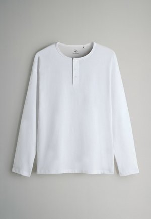 Witte langemouwen henleyshirt van zachte katoen, met een ronde hals, een drie-knopen-sluiting en zijsplitten aan de zoom.