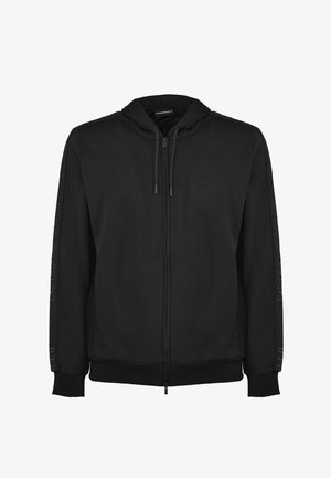 Sudadera con cremallera negra fabricada en un tejido suave. Presenta una capucha con cordón, puños acanalados y acentos laterales con una marca en relieve.