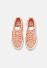 Pink canvas sneakers with white rubber soles, round toes, and lace-up design; features subtle branding on tongue and side.