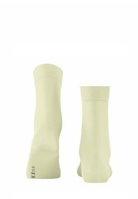 Calzini alla caviglia giallo chiaro con polsino a costine, texture liscia e un'etichetta di dimensioni stampata alla base. Design minimalista.