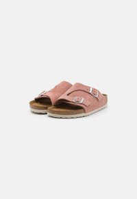 Sandali in suede rosa con fibbie argentate regolabili, soletta in sughero e suola in gomma bianca, caratterizzati da un design open-toe e uno stile minimalista.