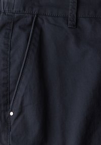 Marinblå shorts tillverkade av lättviktsmaterial, med en diagonalt placerad ficka med silverdetaljer och subtila sömnadsdetaljer.