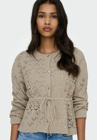 Beezakasvard beežis värvitoonis, tekstuurse mustriga, ümar kaelus, südamekujuliste nööpide ja vööga detailiga.